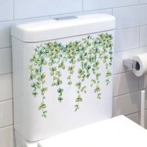 Detailed view of watercolor green vine stickers applied on a white toilet tank surface