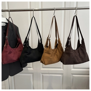 Detail of four large faux suede tote bags in burgundy, black, camel, and coffee colors