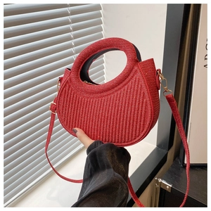 Detailed view of red glitter texture and vertical striped pattern on an arc-shaped bag