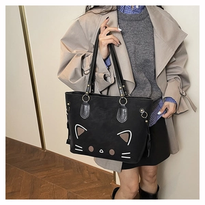 Detail of the black tote bag with cute cat graphic and polished metal hardware accents
