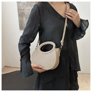 Detail of metallic woven shoulder bag with unique cutout handle and adjustable strap
