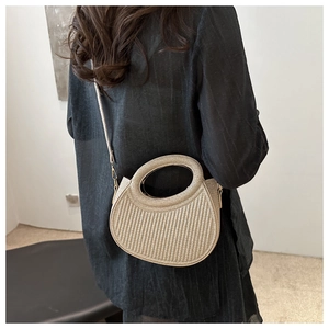 Détail d'un sac à main plissé champagne avec texture verticale et poignée ronde