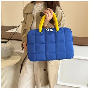Detail of blue quilted laptop bag with yellow handles and white dual zipper pulls