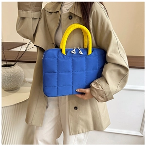 Détail d'une sacoche d'ordinateur bleue matelassée avec des poignées jaunes rembourrées