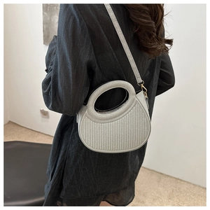 Silver semi-circular bag with vertical stripe texture and metal strap on model