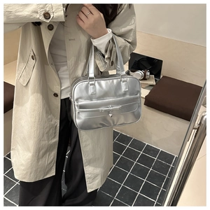 Detail of silver metallic bowling bag with heart pendant and decorative bow detail