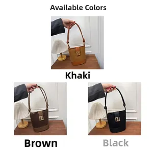 Close-up of elegant suede bucket bags in khaki, brown, and black with metallic buckles