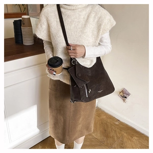 Détail du sac bandoulière vintage marron foncé avec fermeture éclair argentée et mini pochette