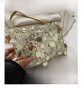 Close-up of champagne gold sequined evening bag with metallic discs and thin strap