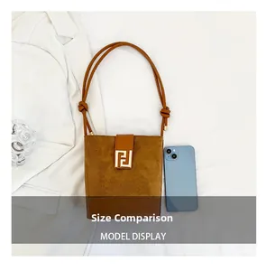 Detailed comparison showing brown bucket bag size relative to a smartphone