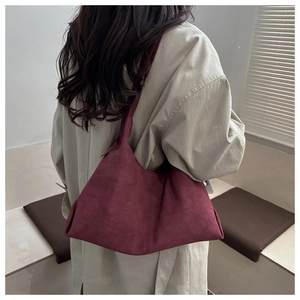 Close-up of burgundy suede hobo bag shoulder strap and premium texture finish
