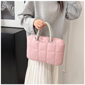 Detailed view of pink quilted laptop briefcase with green handles and double zippers