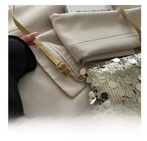 Detail of adjustable shoulder strap with metal buckle on the gold sequin shoulder bag