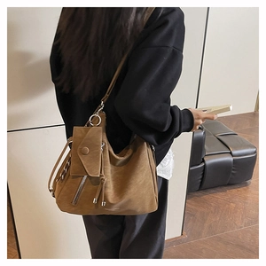 Detalle del bolso tote color caramelo con estuche desmontable y borlas elegantes