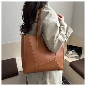 Caramel brown large tote bag shown on shoulder with unique geometric stitching detail