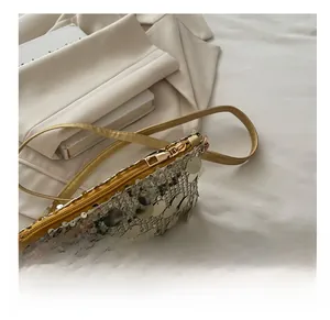 Close-up of smooth golden zipper and shimmering sequin texture on crescent bag