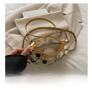 Interior view showing capacity of sequin crossbody bag with phone and cosmetics