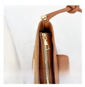 Detail of smooth metal zipper and textured brown suede stitching on the handbag