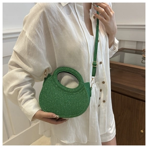 Detail of vibrant green glitter crossbody bag shown on a model for scale and fit