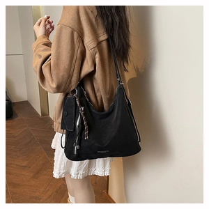 Detail of black soft leather tote bag with a matching small zipper pouch accessory