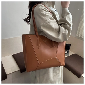 Detail of caramel brown tote bag with geometric triangular stitching and smooth texture