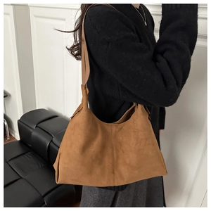 Brown suede tote bag with wide shoulder strap shown on model for daily commuting style