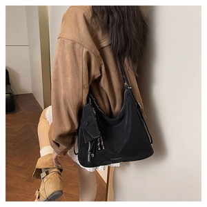 Détail du grand sac hobo noir avec petite pochette porté par un mannequin
