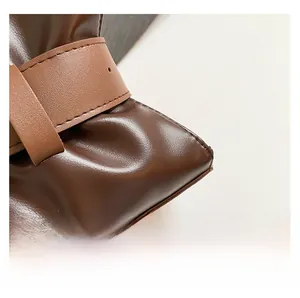 Dettaglio ravvicinato della texture in pelle pieghettata marrone scuro della borsa