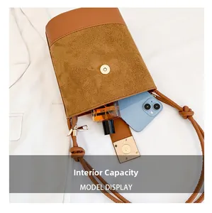 Detail view of brown bucket bag interior capacity with magnetic gold buckle closure