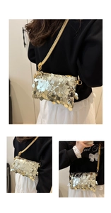 Detail shot of sparkling silver sequin crossbody bag with golden chain strap for evening