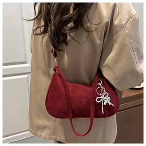 Detail of burgundy matte shoulder bag with a sparkling silver rhinestone bow charm