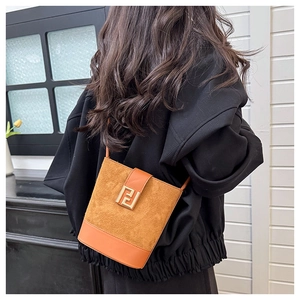 Detail of suede and smooth leather bucket bag with metal buckle and shoulder strap