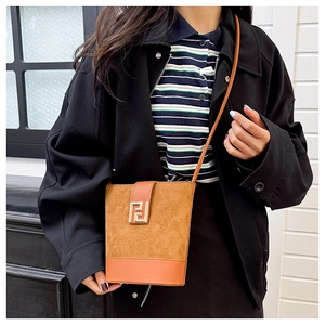 Detail view of brown bicolor bucket bag with suede texture and gold geometric buckle
