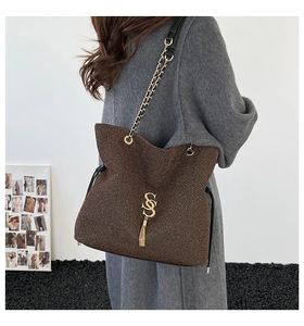 Détail du sac cabas bronze scintillant avec logo SS doré, franges et bandoulière en chaîne