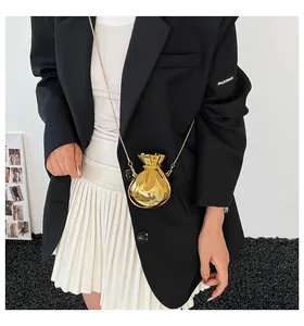 Close-up of golden metallic drawstring money bag with fine gold cross chain strap