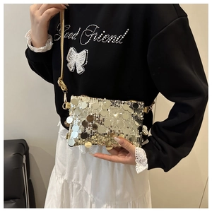Detail view of gold sequin mini crossbody bag with metallic hook and thin shoulder strap