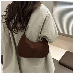 Détail de la texture en daim givré marron sur le sac à bandoulière en forme de croissant