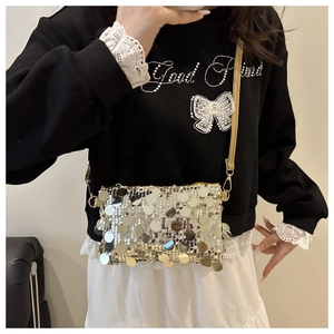 Detail of silver sequin mini crossbody bag with gold strap and white lace trim detail