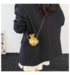 Detailed view of a gold fortune bag mini crossbody purse with a thin metal chain strap