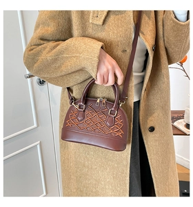 Detail of vintage dark brown shell bag featuring 3D woven texture and gold hardware