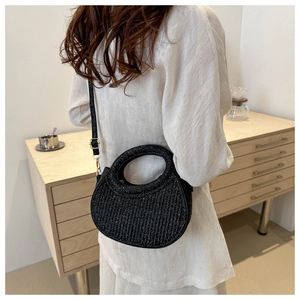 Detail of black sequin crescent crossbody bag with metallic vertical texture on model