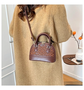 Detail of dark brown shell bag showing retro woven texture and gold-tone hardware