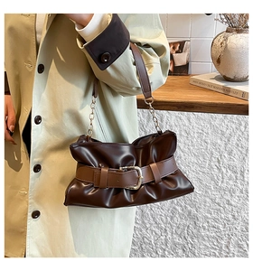 Dettaglio della borsa tote in pelle marrone scuro con fibbia e manico a catena