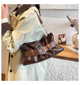 Dettaglio borsa tote in pelle marrone vintage con fibbia dorata e tracolla a catena