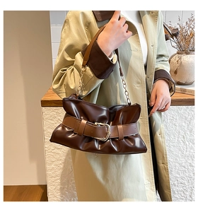 Dettaglio ravvicinato della borsa tote in pelle marrone con fibbia e tracolla a catena