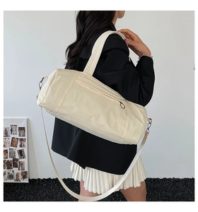 Detailed view of cream nylon bowling tote bag worn with a chic minimalist outfit