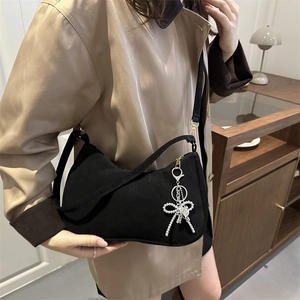 Minimalist black crescent crossbody bag with silver bow charm and adjustable strap