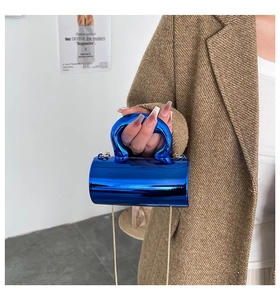 Nahaufnahme der glänzend blauen Zylindertasche mit großem Griff und goldener Metallkette