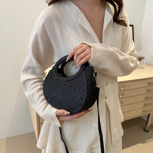 Fashionable black crescent handbag with glitter finish and vertical quilted texture