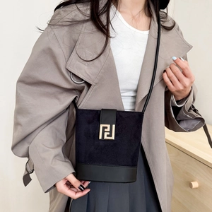 Elegant black suede bucket bag with gold geometric buckle and leather strap